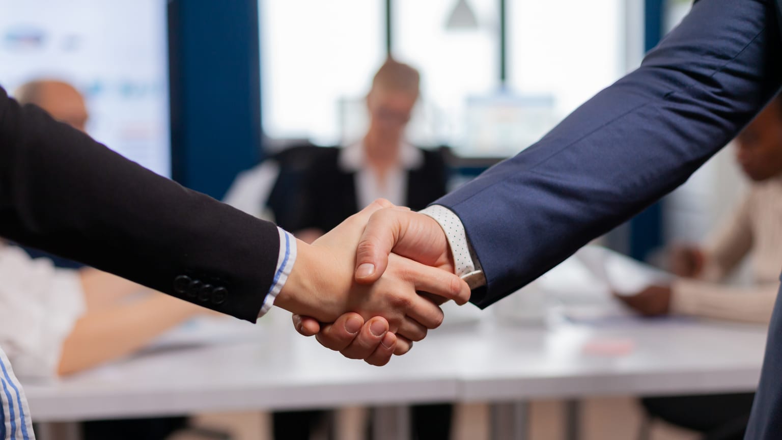 An employer shaking hands with a new employee — signing an employment contract