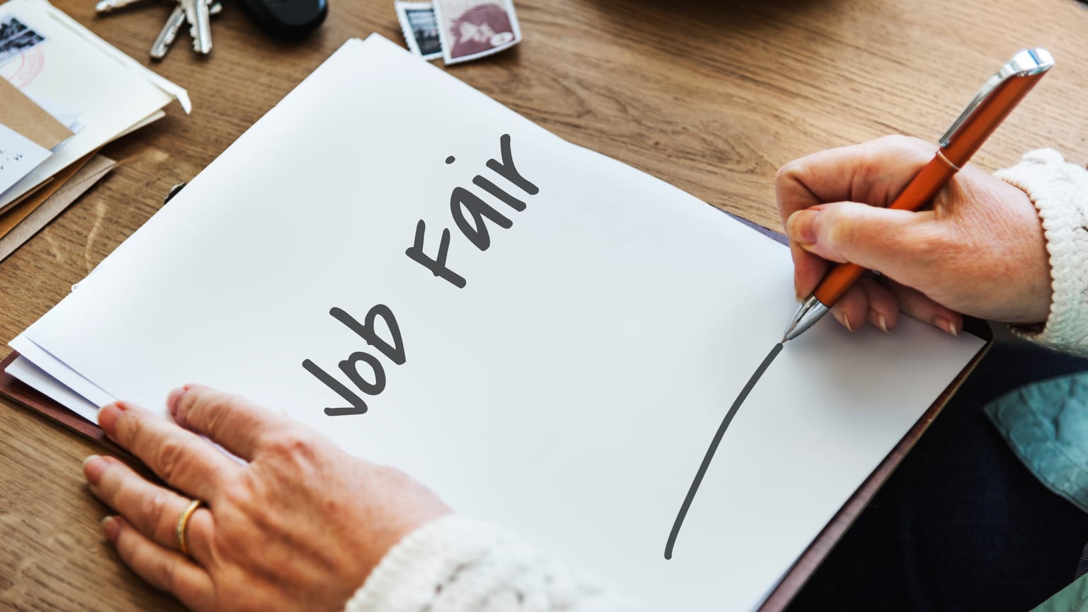 A hand writing Job Fair on paper — where to look for job vacancies